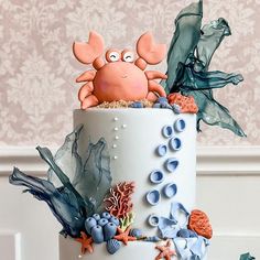 there is a cake decorated with sea animals on the top and under it are shells