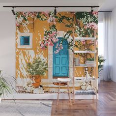 a room with a blue door and flowers on the wall