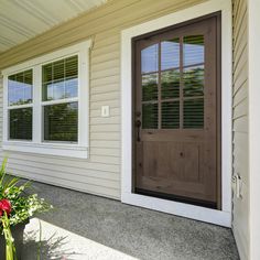 a brown front door on a white house