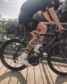 a man riding a bike on top of a sidewalk