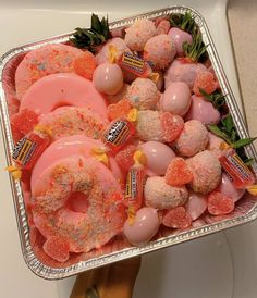 a tray filled with donuts covered in pink and orange sprinkles on top of a counter