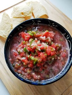 a bowl of salsa with tortilla chips on the side