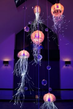 a bunch of jellyfish hanging from a ceiling in a room with purple walls and flooring