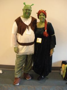 two people dressed up in costumes standing next to each other on carpeted flooring