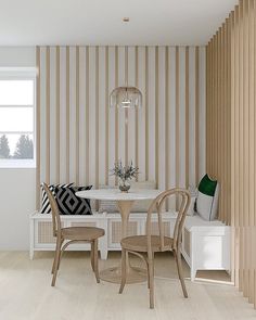 a dining room with striped wallpaper and wooden chairs in the corner next to a white table