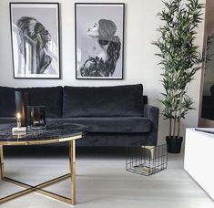 a living room with two pictures on the wall and a coffee table in front of it