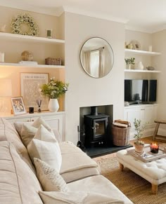 a living room filled with furniture and a fire place next to a wall mounted tv