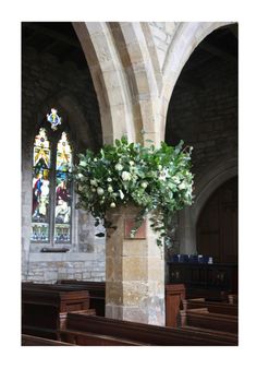 flowers are placed in a vase on the pews at a church altar with stained glass windows