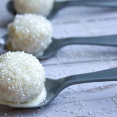 three spoons filled with rice balls on top of a table