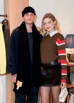 a man and woman standing next to each other in front of a closet with clothes