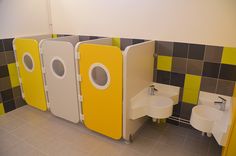 the bathroom is decorated in yellow and grey colors with two urinals on each side