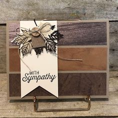 a card with some leaves on it and the words sympathy written in black, white, and brown