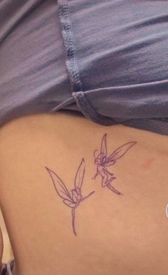 a woman's stomach with a small tattoo on the side of her belly and two hummingbirds