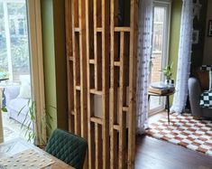 a living room with green walls and wood paneling on the wall, next to an open door