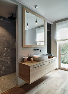 a bathroom with two sinks and a large mirror on the wall next to a window