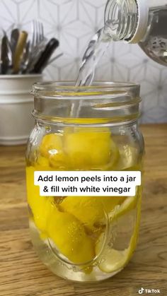 a jar filled with lemons sitting on top of a wooden table