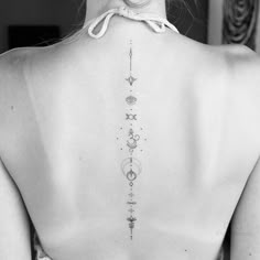 the back of a woman's neck with tattoos on it