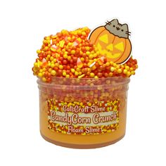 a tub filled with candy corn and a hello kitty sticker on top of it