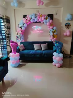 a living room decorated with balloons and streamers in pink, blue, and purple colors