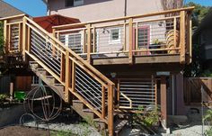 a wooden deck with metal railings next to a house