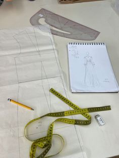 a drawing and measuring tape sit on top of a table