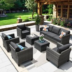 an outdoor living room with grey wicker furniture