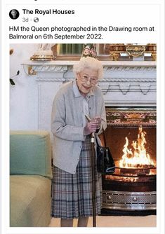 an older woman standing in front of a fire place holding a cane and looking at her cell phone