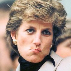 a close up of a person wearing a suit and tie with her finger in her mouth