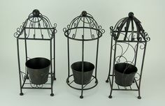 three metal bird cages with buckets in them on wheels against a white background,