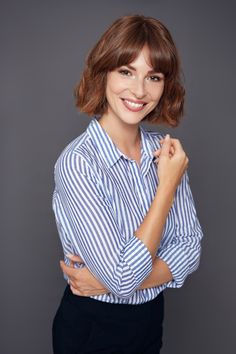 a smiling woman with her arms crossed