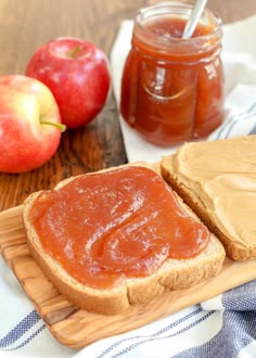 two pieces of bread with peanut butter and an apple on the side next to them