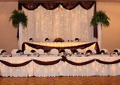 a banquet table set up with white linens and place settings for people to eat