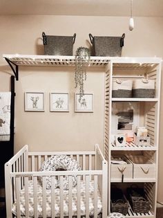 a baby's room with a crib, shelves and pictures on the wall