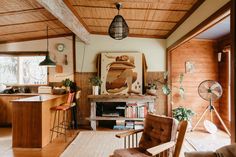 a living room filled with furniture next to a wooden kitchen and dining room table in front of a window