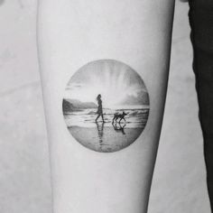 a black and white photo of a person with a dog walking on the beach at sunset