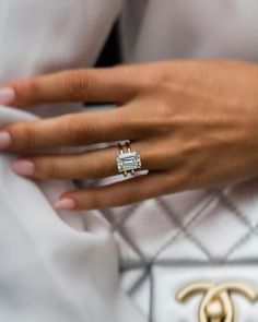 a woman's hand wearing a diamond ring