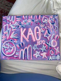 a painting with letters and numbers painted on it in pink, blue, and purple