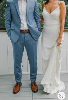 a man and woman standing next to each other in front of a window holding hands