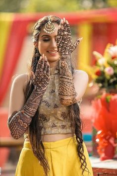 a woman with her hands covered in henna and holding up her hand to the camera