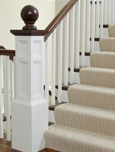 a stair case next to a set of stairs with carpet on the floor and handrails