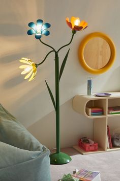 a living room with a flower lamp on the wall and a round mirror above it