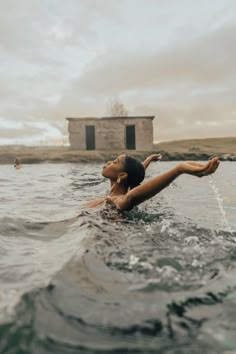 a woman is swimming in the water with her arms outstretched and head above the water's surface