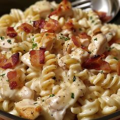 a close up of a pasta dish with chicken and bacon