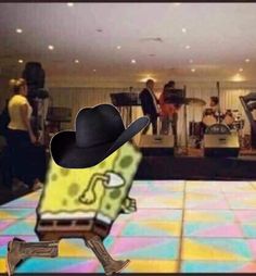 a man in a black hat is dancing on the dance floor with other people behind him