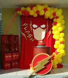 a birthday party with balloons and decorations for the flash man theme on display in front of a red backdrop