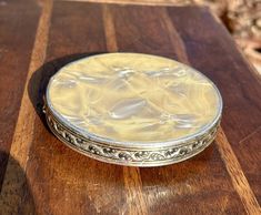 a small silver plate sitting on top of a wooden table