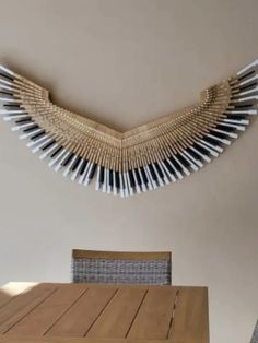 a dining room table with chairs and a sculpture made out of pencils on the wall