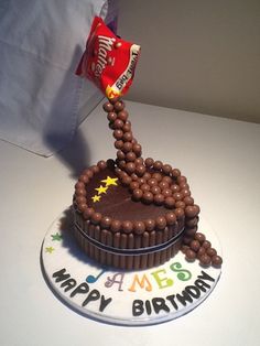 a birthday cake with chocolate frosting and candies on the top that says happy birthday