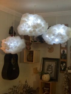 some white clouds are floating in the air above a room with pictures on the wall