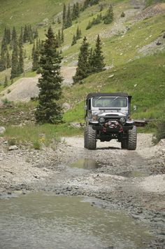 a jeep driving down a dirt road in the mountains